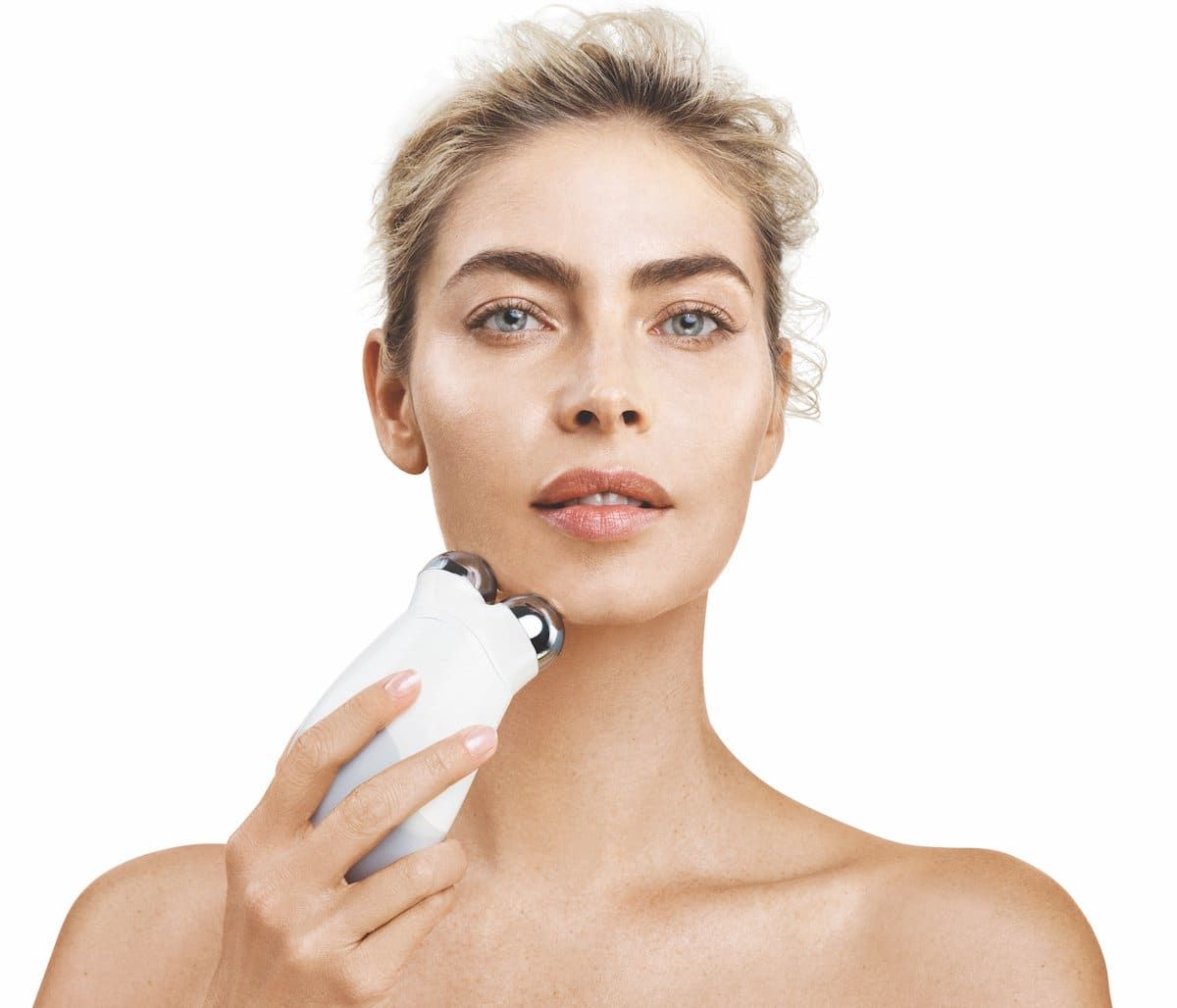 NuFACE Trinity microcurrent device against woman's skin, clean clinical hero
