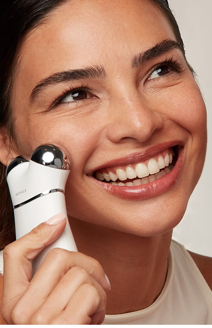 NuFACE Mini close-up on cheek, the travel-tier entry device in use